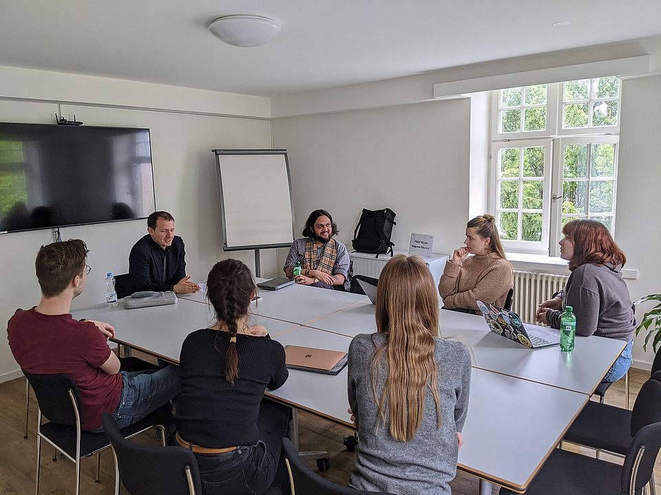 Studierende in Arbeitsgruppe rund um einen Tisch